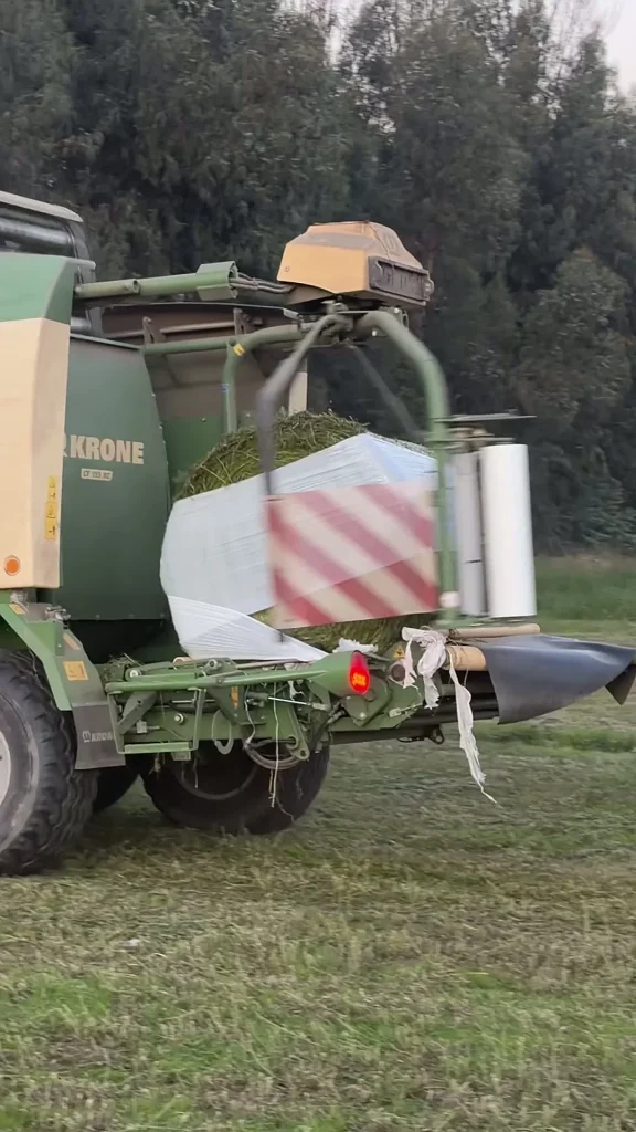 Máquina envolviendo un bolo de forraje en terreno