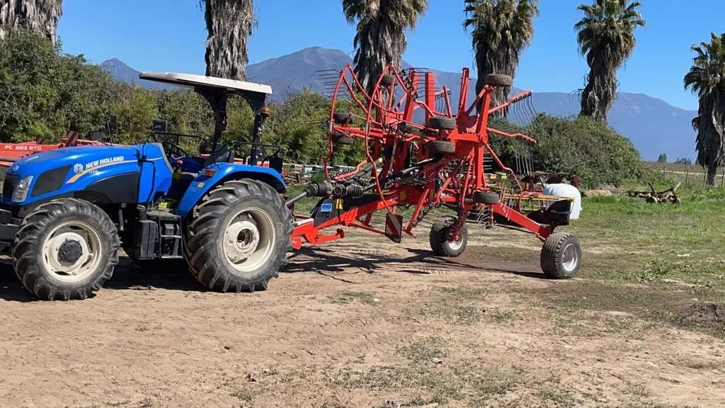 Tractor con rastrillo hilerador